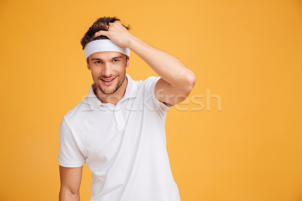 Portrait of smiling attractive young man athlete in headband Stock photo © deandrobot