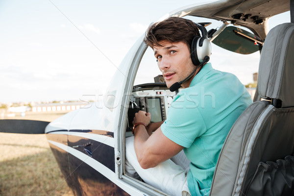 Man pilot sitting in cabin of small airplane Stock photo © deandrobot