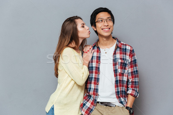Beautiful tender interracial young couple standing and kissing Stock photo © deandrobot