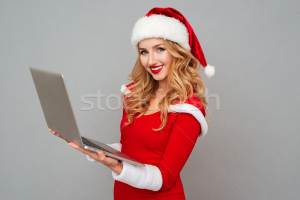 Woman in red santa claus outfit holding laptop Stock photo © deandrobot