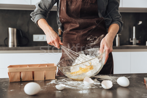 Cropped photo of young woman cooking the dough. Stock photo © deandrobot
