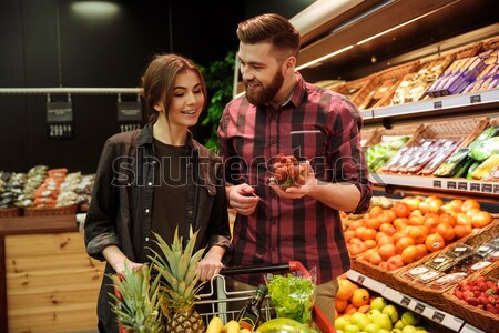 Loving couple in supermarket. Woman looking man holding beer. Stock photo © deandrobot