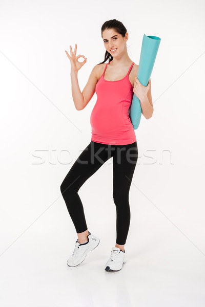 Full length portrait of pregnant fitness woman showing ok sign Stock photo © deandrobot