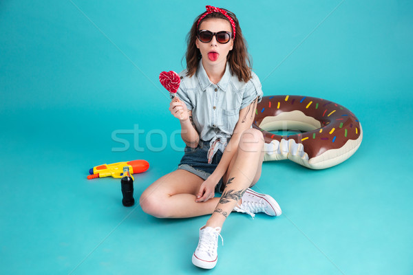 Pretty young lady eating candy. Stock photo © deandrobot
