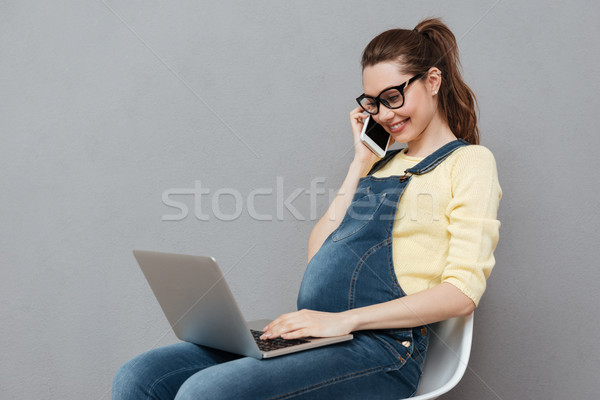 Foto stock: Embarazadas · feliz · dama · usando · la · computadora · portátil · hablar · teléfono