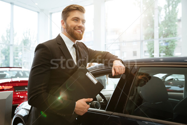 Lächelnd jungen Auto Verkäufer stehen Stock foto © deandrobot
