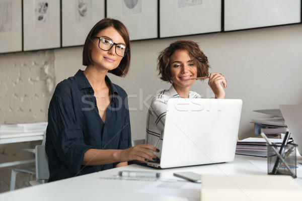 Two young happy women working by the table Stock photo © deandrobot