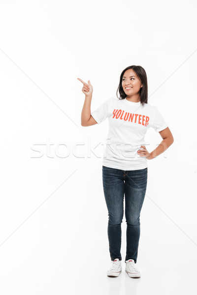 Portrait of a pretty joyful asian woman in volunteer t-shirt Stock photo © deandrobot