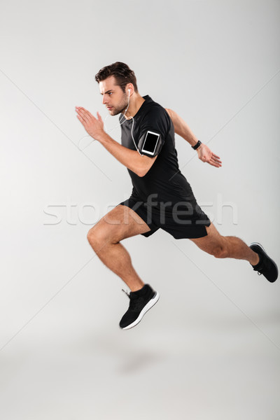 Side view full length portrait of a confident young man Stock photo © deandrobot