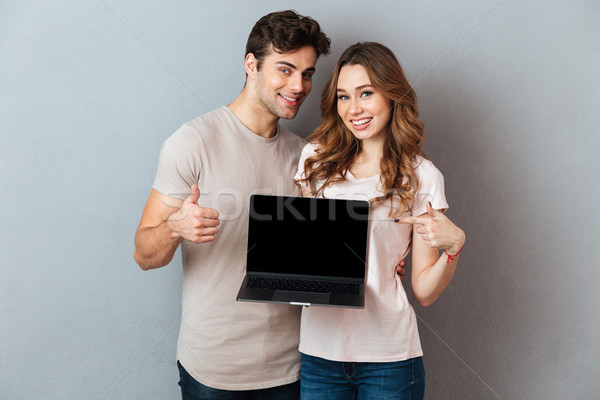 портрет пару указывая экране портативного компьютера улыбаясь Сток-фото © deandrobot