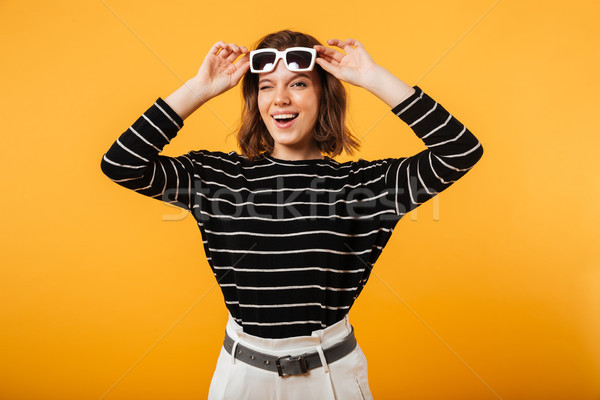Portrait of a cheerful girl in sunglasses winking Stock photo © deandrobot