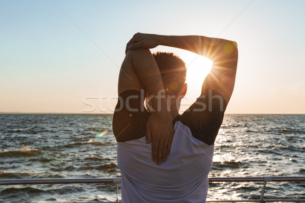 Back view of a sportsman stretching hands Stock photo © deandrobot