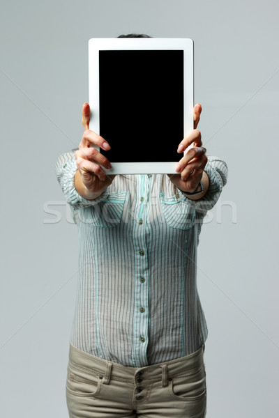 Woman showing tablet computer screen on gray background Stock photo © deandrobot