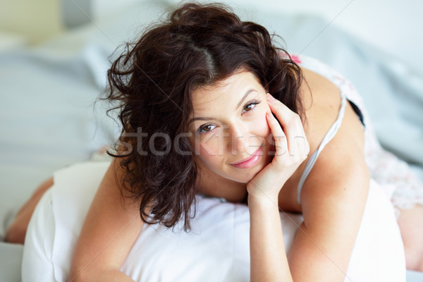 Beautiful woman lying on the sofa and smiling Stock photo © deandrobot