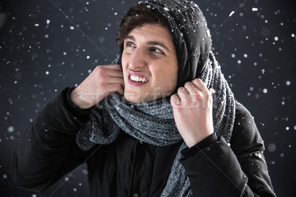 Portrait of a casual man in winter cloth with snow on background Stock photo © deandrobot