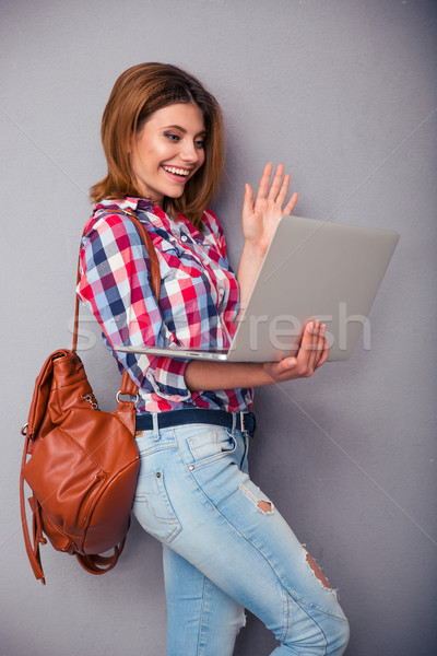 Woman showing greeting gesture to web camera Stock photo © deandrobot