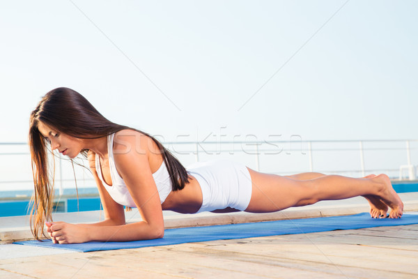 Woman working out on yoga mat  Stock photo © deandrobot