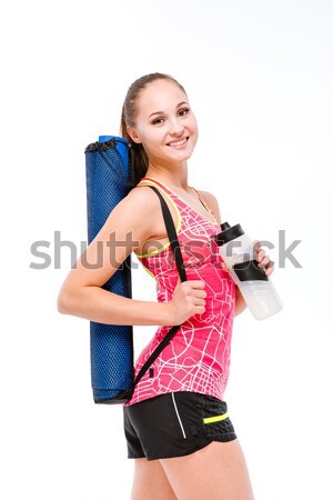 Smiling fitness woman holding shaker and yoga mat Stock photo © deandrobot
