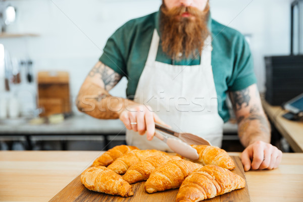 Genç barista sakal kruvasan Stok fotoğraf © deandrobot