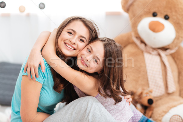 Two cheerful charming sisters embracing at home Stock photo © deandrobot