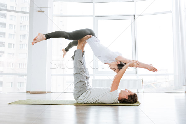 Man and woman doing acro yoga in pair in studio Stock photo © deandrobot