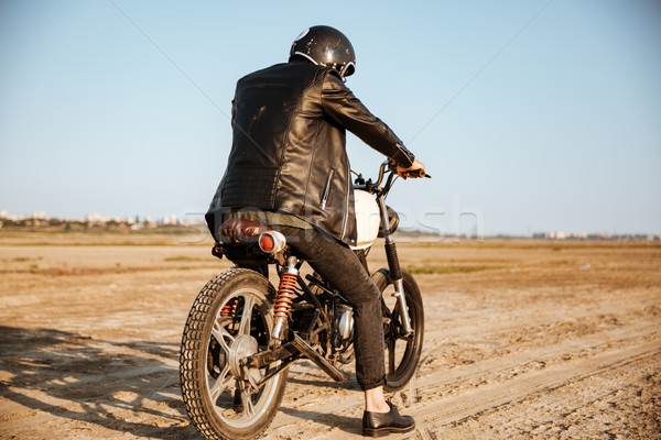 Back view of young brutal man driving a motorcycle Stock photo © deandrobot