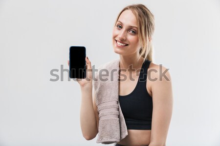 Stock photo: Happy fitness woman showing mobile phone display.