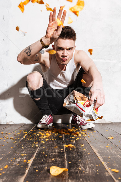 Ingerült fiatalember dob burgonyaszirom ki étel Stock fotó © deandrobot