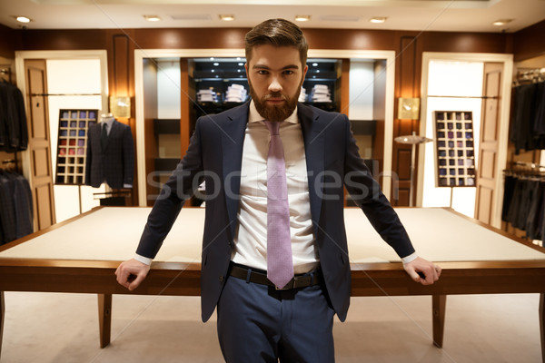 Serious man standing near the table Stock photo © deandrobot