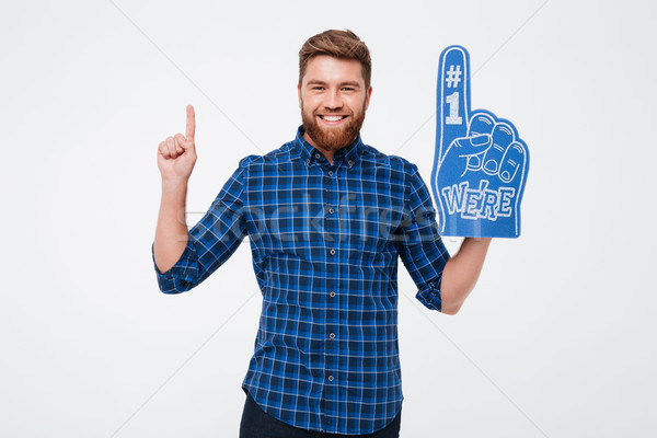 Cheerful man with fan finger pointing up isolated Stock photo © deandrobot
