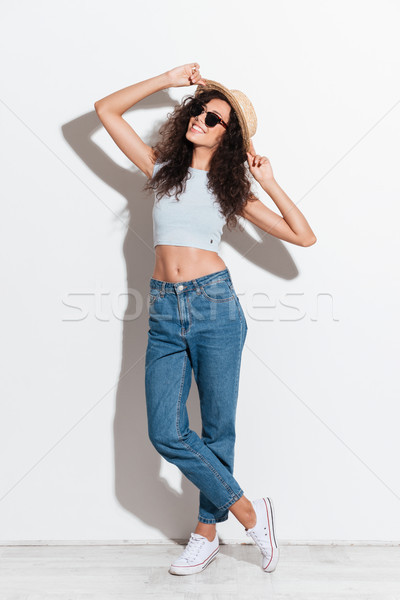 Cheerful woman in jeans hat and sunglasses smiling to camera Stock photo © deandrobot