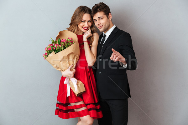 Portrait of a smiling happy couple holding flower bouquet Stock photo © deandrobot