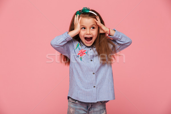 Beautiful little girl reacting emotionally grabbing head with bo Stock photo © deandrobot