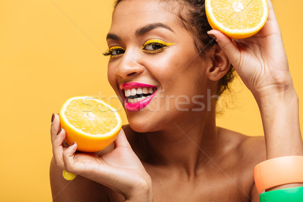Portrait of smiling mulatto woman with colorful makeup tasting j Stock photo © deandrobot