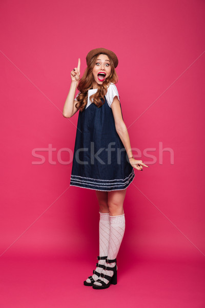 Beautiful happy woman holding finger up while have an idea isolated Stock photo © deandrobot