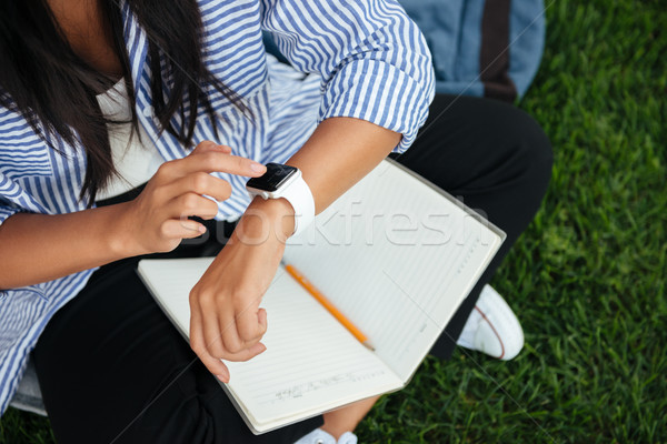 Cropped view of female student cheking time, outdoor Stock photo © deandrobot