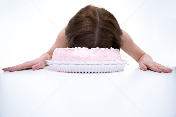 Woman lying on the table with face in cake Stock photo © deandrobot