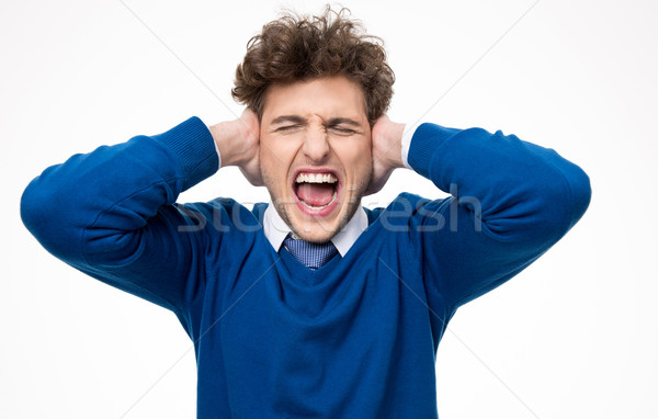 Handsome young man shouting and covering his ears Stock photo © deandrobot