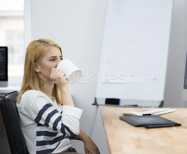 Young girl drinking coffee in office Stock photo © deandrobot