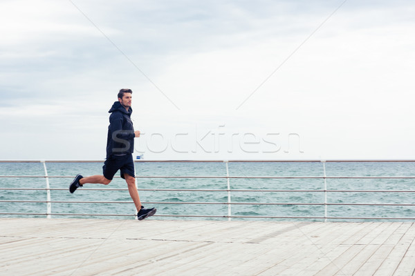 Sports man running near sea o Stock photo © deandrobot