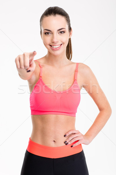 Attractive cheerful young female athlete pointing on you Stock photo © deandrobot
