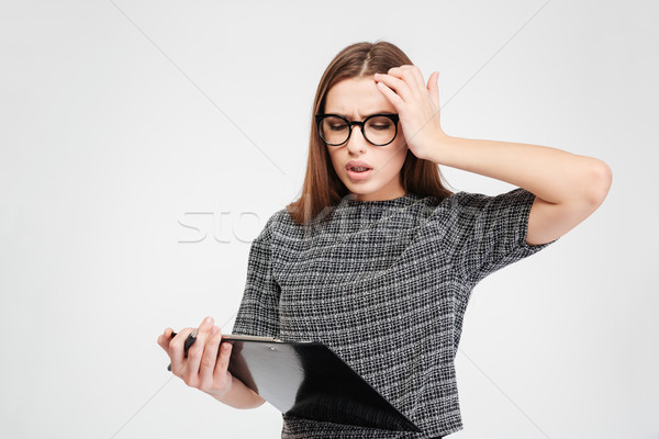 Stressed attractive woman in glassed with clipboard having a headache Stock photo © deandrobot