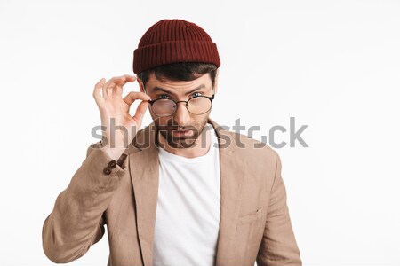 Handsome young man in blue shirt putting on the hat Stock photo © deandrobot