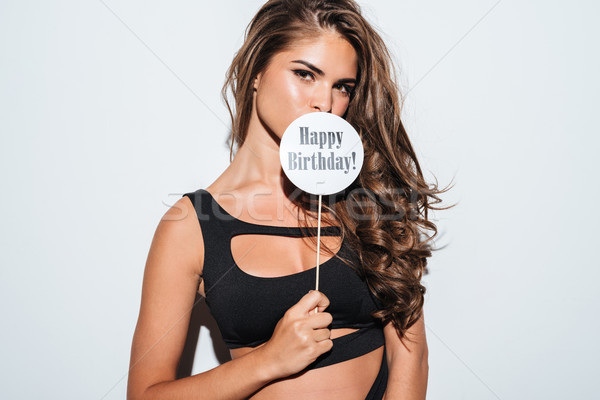 Image of girl in bikini covering mouth with sign Stock photo © deandrobot