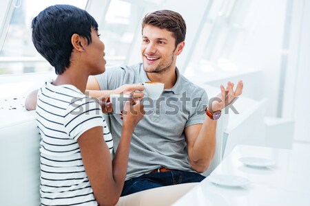 Cheerful young businesspeople standing and discussing bisness plan Stock photo © deandrobot