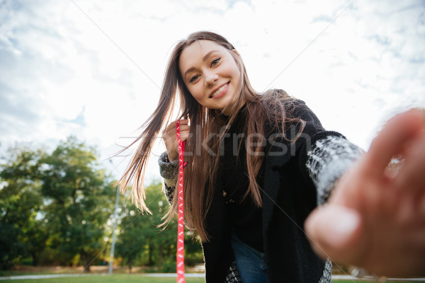 Smiling woman playing and having fun with dog on leash Stock photo © deandrobot