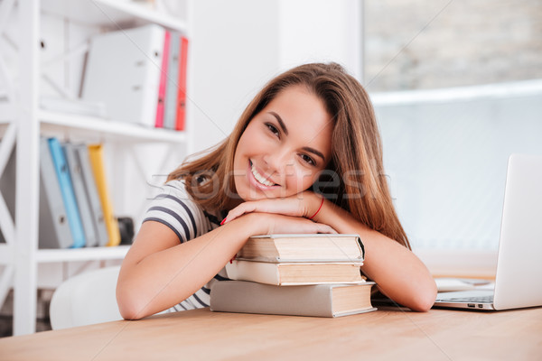 Pretty lady lies on books in classroom and smile Stock photo © deandrobot