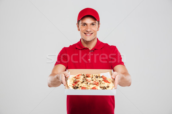 Young delivery man with pizza Stock photo © deandrobot