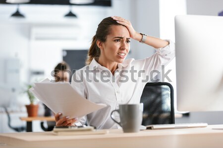 Asian man working and eating by the table Stock photo © deandrobot