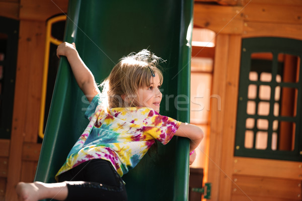 Pretty girl on children's slide Stock photo © deandrobot